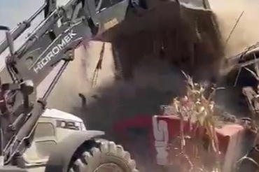 Kepçe, yanan iş makinesinin üzerine toprak boşaltarak söndürmek istedi