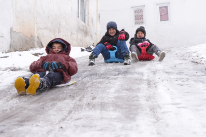 Çocuklar, karla kaplanan dik yokuşu kayak pistine çevirdi