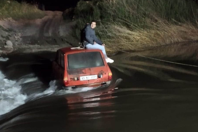 Akıntıya kapılan otomobildeki iki kişi iş makinesiyle kurtarıldı