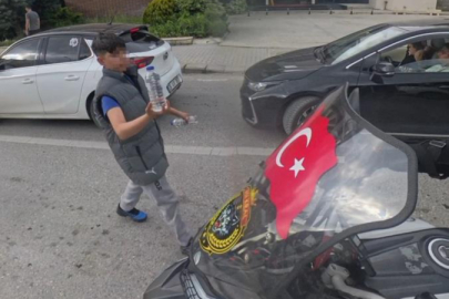 Su satan çocuk, camında Türk bayrağı olan motosikletliye su hediye etmek istedi