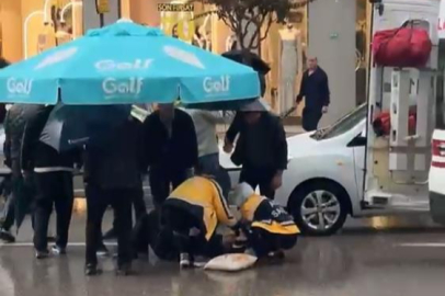 Yolun karşısına geçerken otomobil çarptı: Vatandaşlar yaralıya şemsiye tuttu