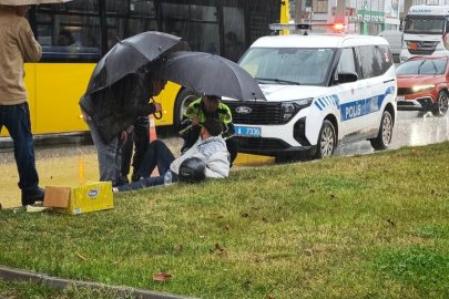 Trafik polisinin yaralı sürücüye ıslanmaması için şemsiye tutması cep telefonu kamerasıyla kaydedildi